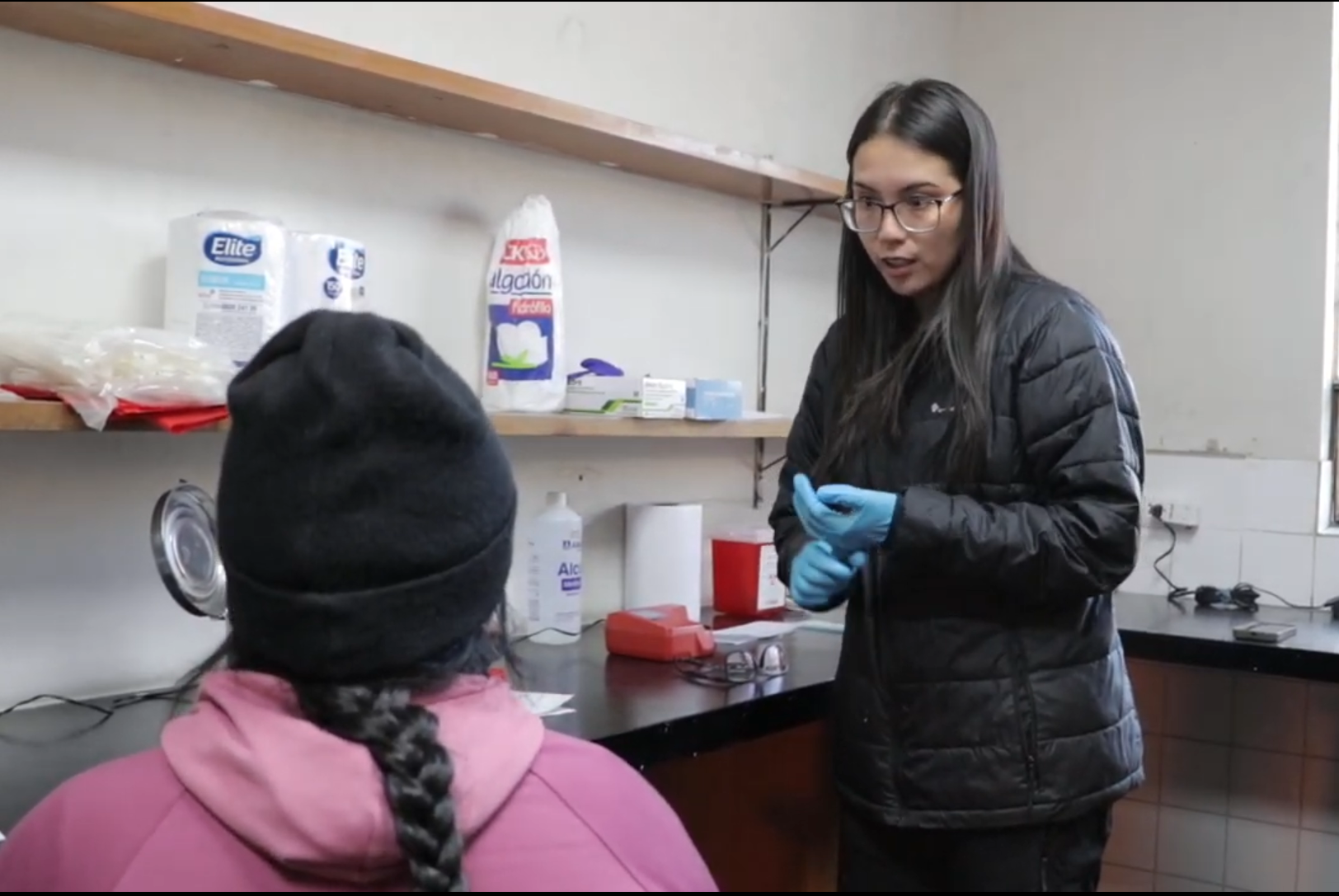 Researcher taking a physiological measurement from a participant at a table in the field laboratory
